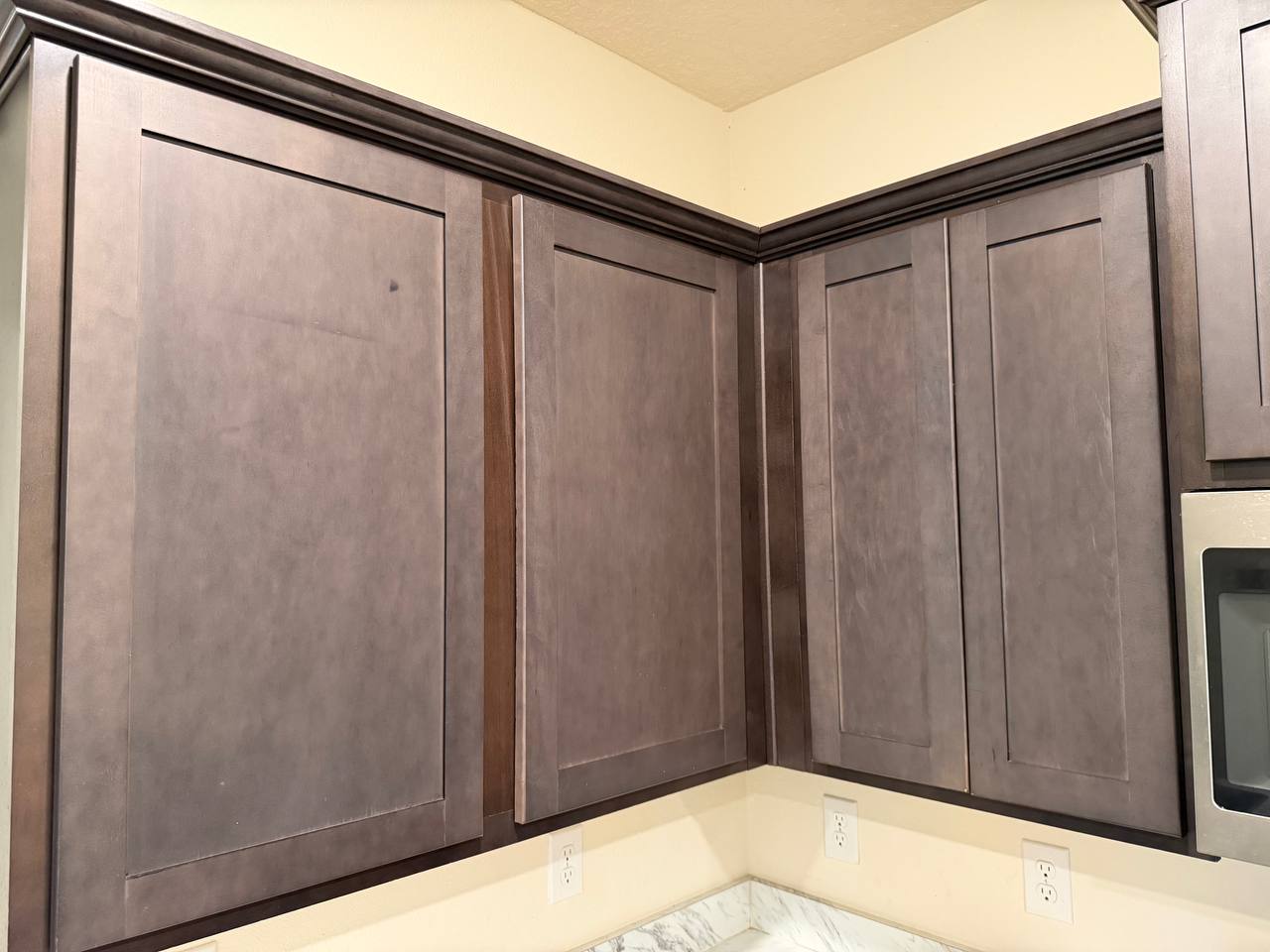Before: the same upper cabinets sanded back to a patchy grey-brown, ready for primer.