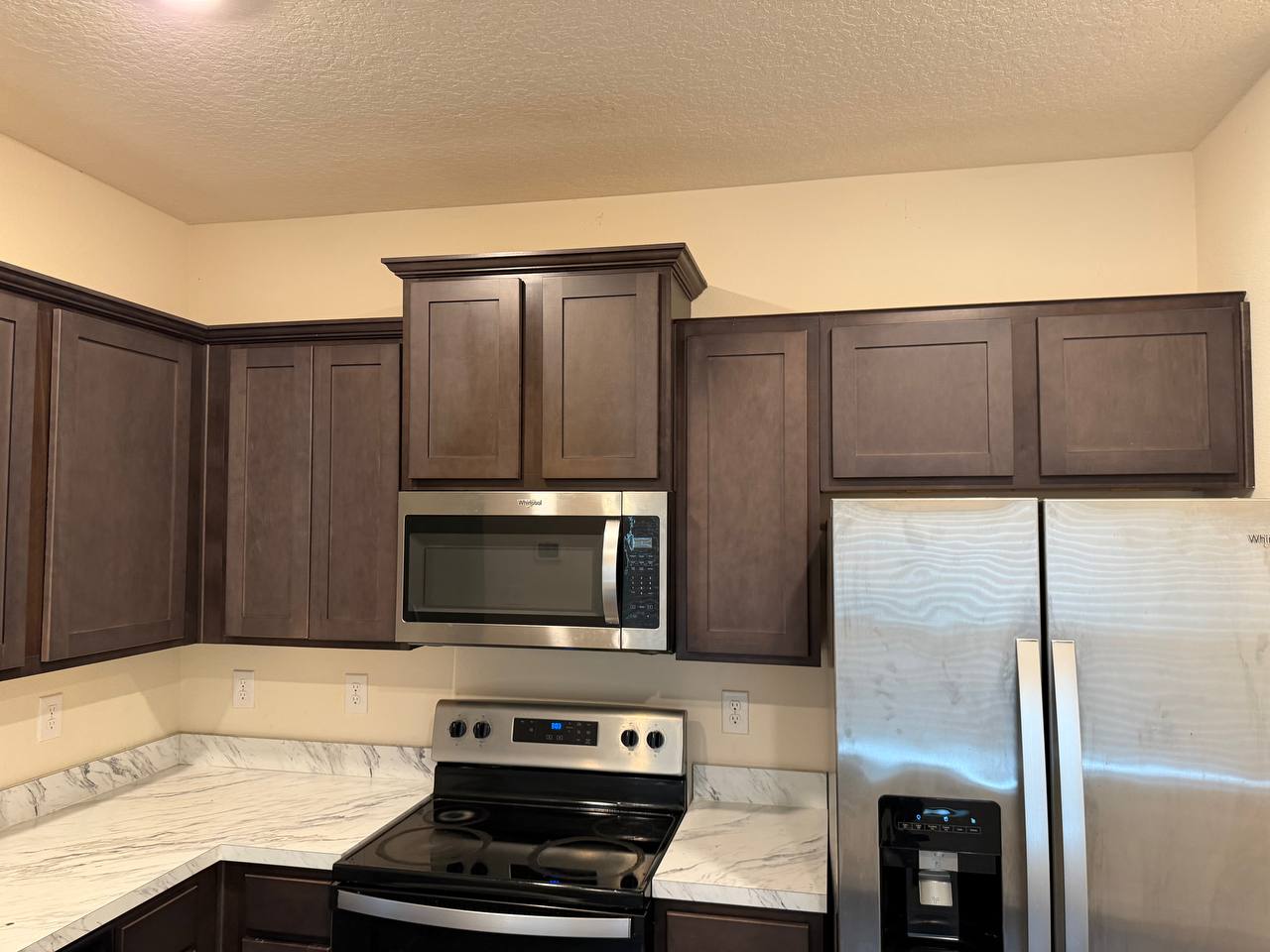 Before: the same kitchen with dull, patchy and worn cabinet doors.
